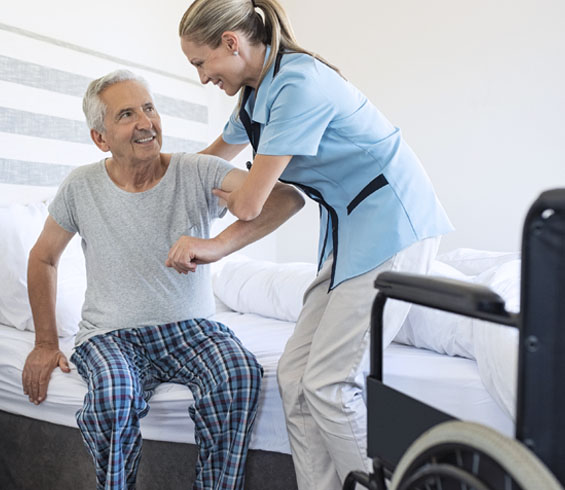 A caregiver helping a patient with mobility support at home